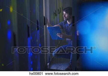 Stock Image - Server room technician with clipboard. Fotosearch