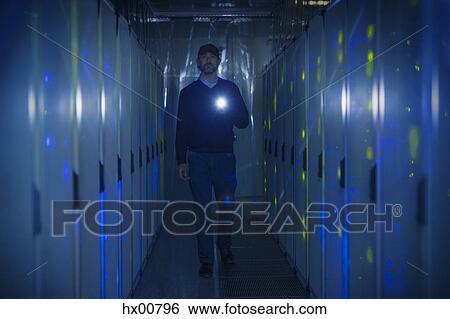 Server room technician with flashlight in dark corridor View Large Photo Image Stock Photograph - Server room technician with flashlight in dark corridor. Fotosearch