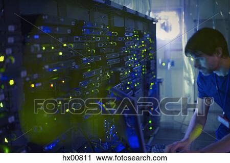 Server room technician working at computer View Large Photo Image Stock Image - Server room technician working at computer. Fotosearch