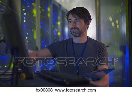 Server room technician working at computer View Large Photo Image Stock Photo - Server room technician working at computer. Fotosearch