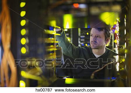 Server room technician working on server panel View Large Photo Image Stock Photo - Server room technician working on server panel. Fotosearch
