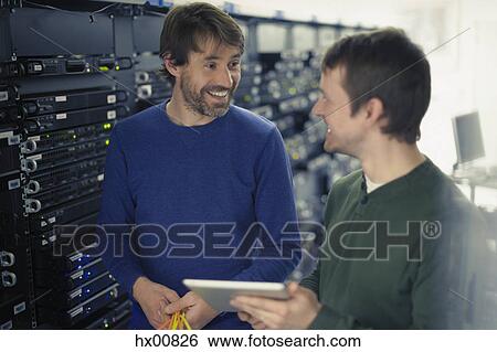 Stock Photograph - Server room technicians using digital tablet. Fotosearch