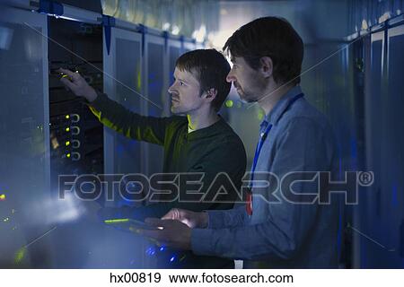 Server room technicians working on panel View Large Photo Image Stock Photo - Server room technicians working on panel. Fotosearch