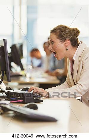 Shocked businesswoman working at computer in office View Large Photo Image Stock Photo - Shocked businesswoman working at computer in office. Fotosearch