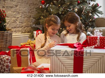 Sisters surrounded by Christmas gifts View Large Photo Image Stock Image - Sisters surrounded by Christmas gifts. Fotosearch