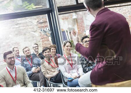 Smiling audience watching presentation at conference View Large Photo Image Stock Photo - Smiling audience watching presentation at conference. Fotosearch