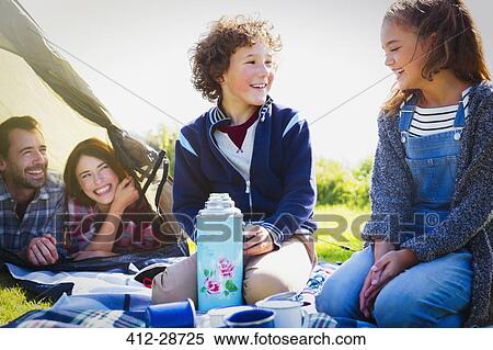 Smiling brother and sister with insulated drink container at campsite View Large Photo Image Stock Photography - Smiling brother and sister with insulated drink container at campsite. Fotosearch