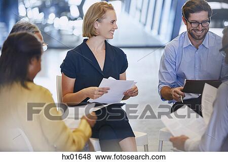 Smiling business people discussing paperwork in meeting View Large Photo Image Stock Photo - Smiling business people discussing paperwork in meeting. Fotosearch