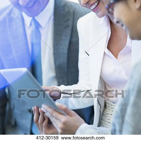 Smiling business people using digital tablet View Large Photo Image Stock Photo - Smiling business people using digital tablet. Fotosearch