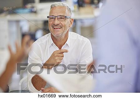 Stock Photo - Smiling businessman in meeting. Fotosearch