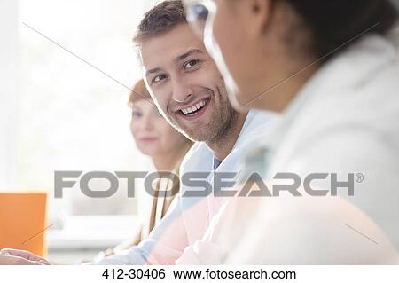 Stock Photograph - Smiling businessman in meeting. Fotosearch