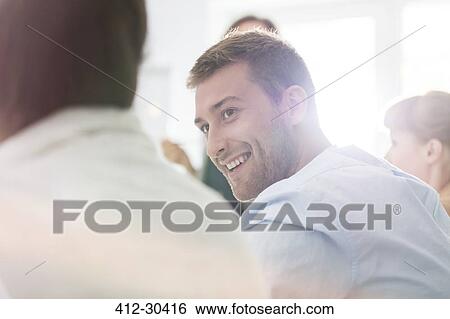 Smiling businessman listening in meeting View Large Photo Image Stock Photograph - Smiling businessman listening in meeting. Fotosearch