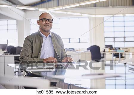 Stock Photography - Smiling businessman listening in meeting. Fotosearch