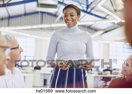 Smiling businesswoman leading meeting View Large Photo Image Stock Photo - Smiling businesswoman leading meeting. Fotosearch