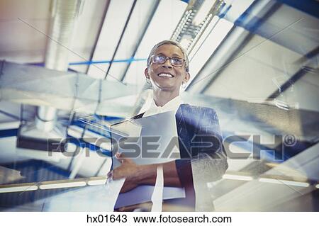 Stock Image - Smiling businesswoman looking away. Fotosearch