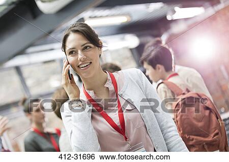 Stock Photograph - Smiling businesswoman talking on cell phone at conference. Fotosearch