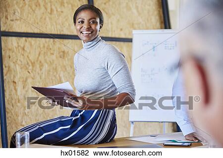 Smiling businesswoman with paperwork in meeting View Large Photo Image Stock Image - Smiling businesswoman with paperwork in meeting. Fotosearch