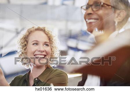 Smiling businesswomen in meeting View Large Photo Image Stock Photograph - Smiling businesswomen in meeting. Fotosearch