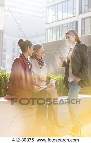 Smiling businesswomen with digital tablet and the coffee talking outdoors View Large Photo Image Stock Photography - Smiling businesswomen with digital tablet and the coffee talking outdoors. Fotosearch