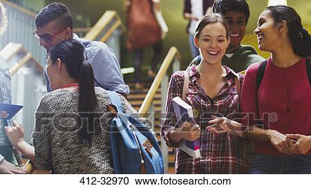 Stock Image - Smiling college students in stairway. Fotosearch