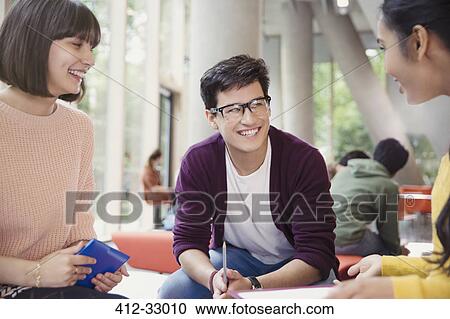 Stock Image - Smiling college students talking in commons. Fotosearch
