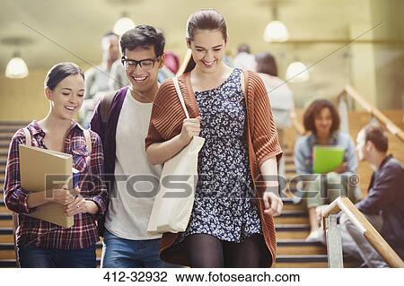 Stock Image - Smiling college students walking in stairway. Fotosearch