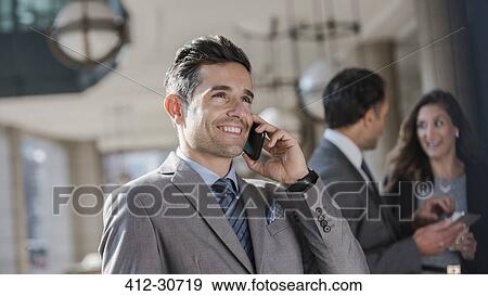 Stock Photo - Smiling corporate businessman talking on cell phone. Fotosearch