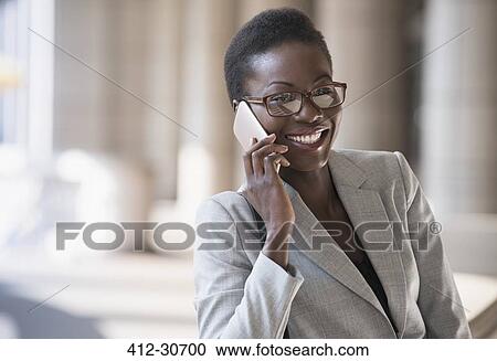 Stock Image - Smiling corporate businesswoman talking on cell phone. Fotosearch