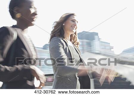 Smiling corporate businesswomen walking outdoors View Large Photo Image Stock Image - Smiling corporate businesswomen walking outdoors. Fotosearch