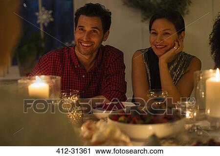 Smiling couple enjoying candlelight Christmas dinner View Large Photo Image Stock Image - Smiling couple enjoying candlelight Christmas dinner. Fotosearch