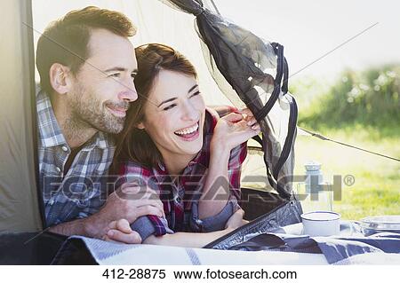 Smiling couple peering from inside tent View Large Photo Image Stock Photography - Smiling couple peering from inside tent. Fotosearch