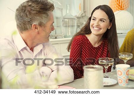 Stock Photo - Smiling couple talking and drinking champagne at party table. Fotosearch