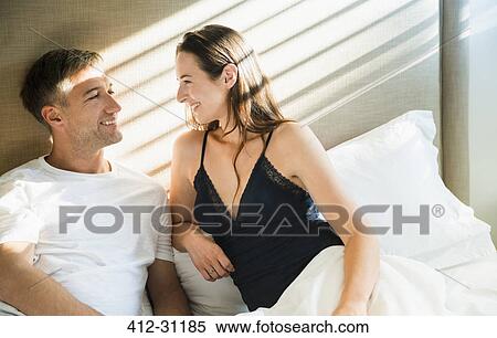 Smiling couple talking in bed View Large Photo Image Stock Photography - Smiling couple talking in bed. Fotosearch
