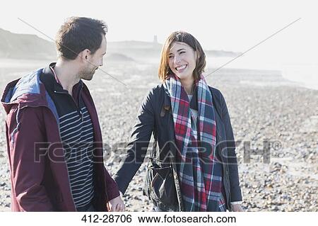 Smiling couple walking on beach View Large Photo Image Stock Photograph - Smiling couple walking on beach. Fotosearch