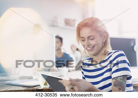 Smiling creative young businesswoman using digital tablet View Large Photo Image Stock Photography - Smiling creative young businesswoman using digital tablet. Fotosearch