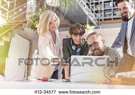 Smiling design professionals meeting at laptop in office View Large Photo Image Stock Photo - Smiling design professionals meeting at laptop in office. Fotosearch