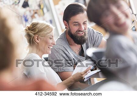 Smiling design professionals meeting and discussing paperwork in office View Large Photo Image Stock Image - Smiling design professionals meeting and discussing paperwork in office. Fotosearch