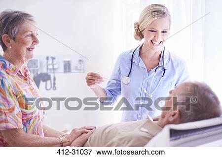 Smiling doctor checking senior mans temperature View Large Photo Image Stock Photo - Smiling doctor checking senior mans temperature. Fotosearch