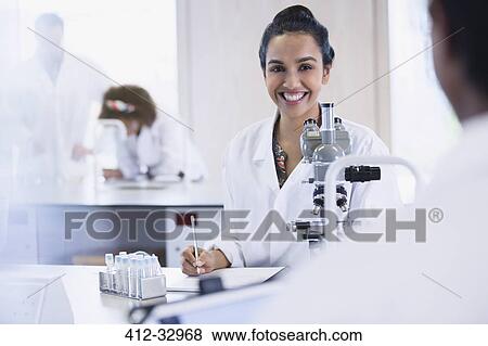 Smiling female college student conducting scientific experiment in science laboratory classroom View Large Photo Image Stock Photo - Smiling female college student conducting scientific experiment in science laboratory classroom. Fotosearch