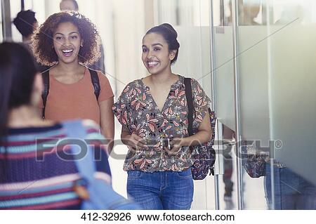 Smiling female college students walking in corridor View Large Photo Image Stock Photograph - Smiling female college students walking in corridor. Fotosearch