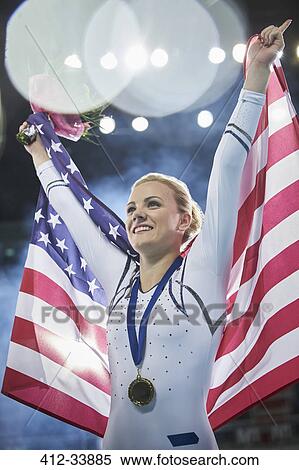 Smiling female gymnast celebrating victory holding American flag View Large Photo Image Stock Photography - Smiling female gymnast celebrating victory holding American flag. Fotosearch