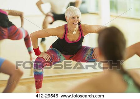 Smiling fitness instructor leading aerobics class View Large Photo Image Stock Photograph - Smiling fitness instructor leading aerobics class. Fotosearch