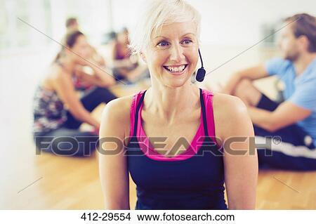 Smiling fitness instructor wearing headset View Large Photo Image Picture - Smiling fitness instructor wearing headset. Fotosearch