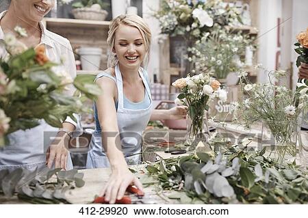 Smiling florist arranging bouquet in flower shop View Large Photo Image Stock Image - Smiling florist arranging bouquet in flower shop. Fotosearch