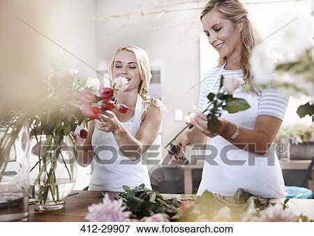 Smiling florists arranging bouquet in flower shop View Large Photo Image Stock Photo - Smiling florists arranging bouquet in flower shop. Fotosearch