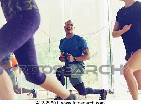 Smiling man lunging in exercise class View Large Photo Image Stock Image - Smiling man lunging in exercise class. Fotosearch