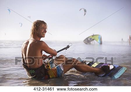 Smiling man ready to kiteboard on beach View Large Photo Image Stock Image - Smiling man ready to kiteboard on beach. Fotosearch