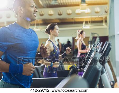Smiling man running on treadmill at gym View Large Photo Image Stock Image - Smiling man running on treadmill at gym. Fotosearch