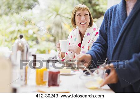 Smiling mature woman drinking coffee in bathrobe at breakfast View Large Photo Image Stock Image - Smiling mature woman drinking coffee in bathrobe at breakfast. Fotosearch
