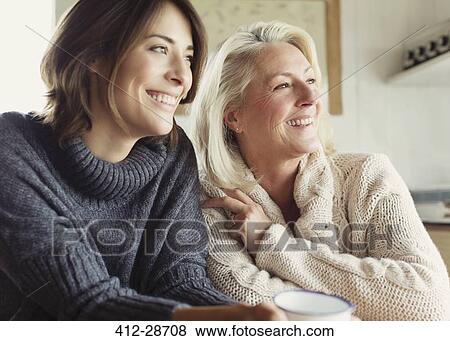 Smiling mother and daughter in sweaters looking away View Large Photo Image Stock Photo - Smiling mother and daughter in sweaters looking away. Fotosearch